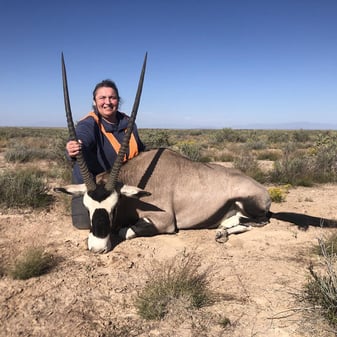 Hunters quartering large elk bull under starry New Mexico sky in broken timber after successful oryx and elk harvests