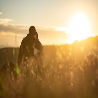 Arizona hunter glassing for elk and antelope in rugged desert terrain under blue skies during application strategy planning