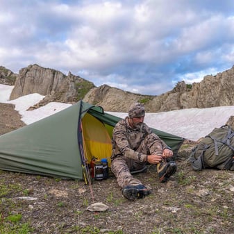 Hunt photographer with tent in storm